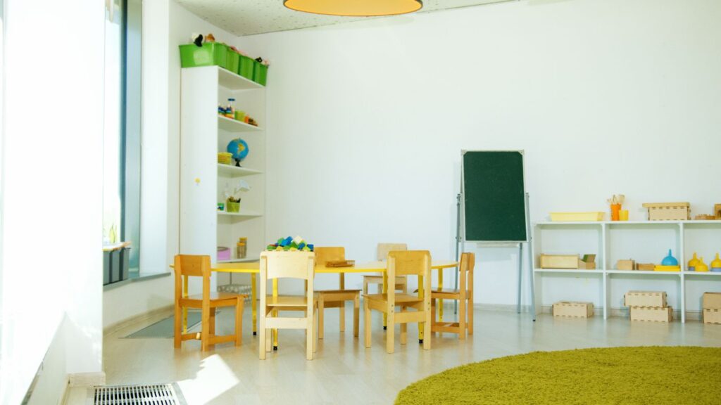 Bright preschool classroom with small tables and chairs
